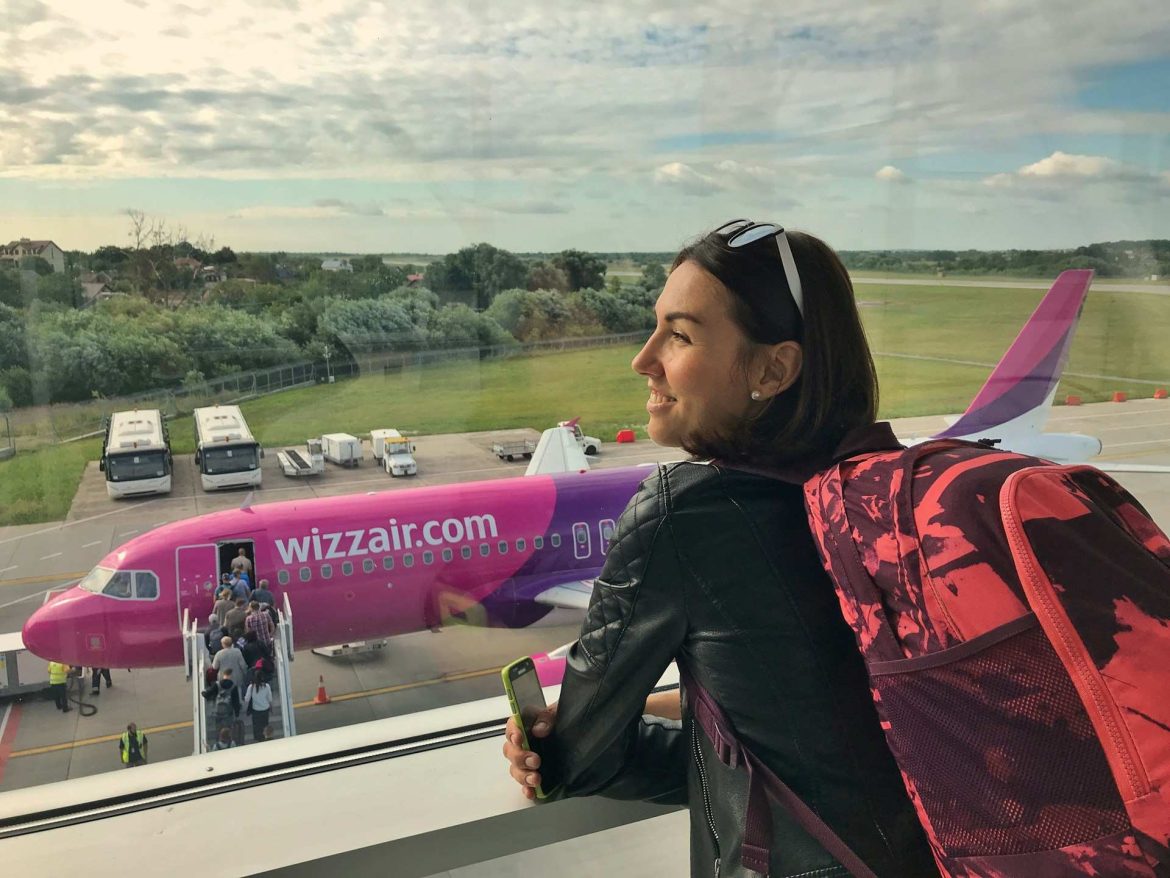 Utas hátizsákkal néz egy Wizz Air repülőgépet a terminálból