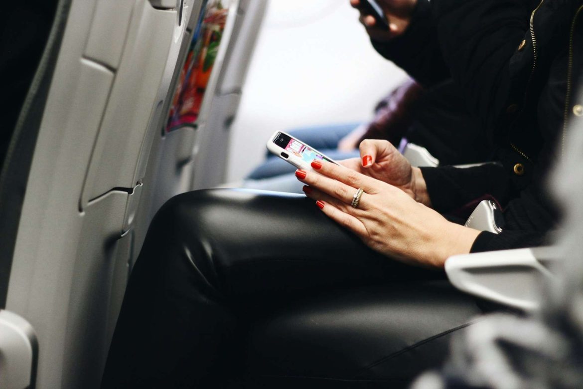 Utas mobiltelefont használ repülés közben egy Wizz Air járat fedélzetén.