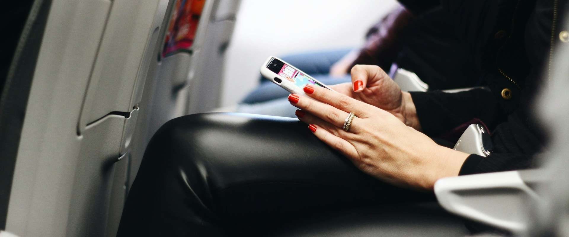 Utas mobiltelefont használ repülés közben egy Wizz Air járat fedélzetén.